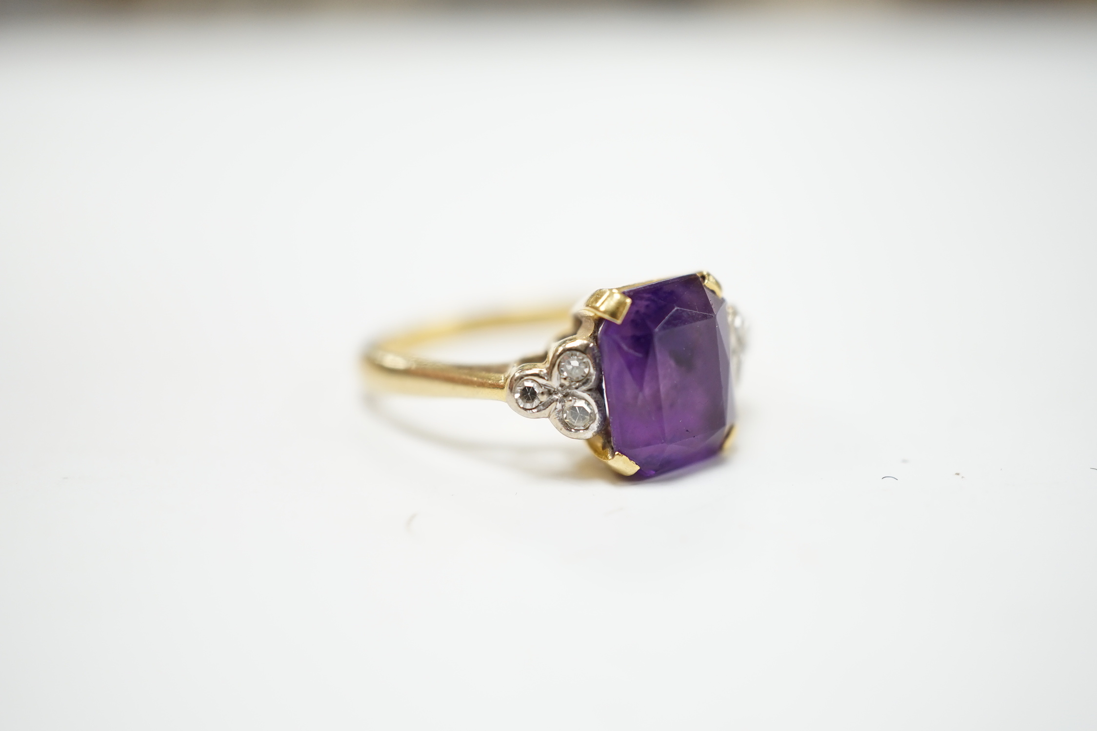 An 18ct and single stone emerald cut amethyst set ring with diamond set shoulders, size M, gross weight 4.5 grams.